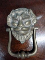 Brass door knocker decorated with lions mask {19 cm H x 12 cm D}.