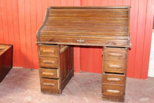 Late 19th C oak roll top desk, the roll top enclosing a fitted interior above eight short drawers {H
