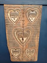 18th C. African granary door with carved heart shape faces and the inner eye