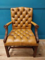 Mahogany deep buttoned leather upholstered Gainsborough armchair with upholstered arms terminating