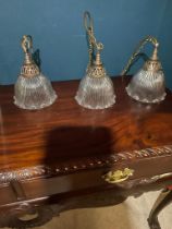 Set of three good quality holophane glass shades with original brass galleries {}.
