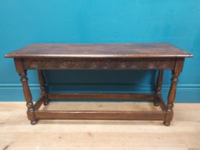 Early 20th C. oak stool with shell motif in frieze on four turned legs. {35 cm H x 92 cm W x 31 cm