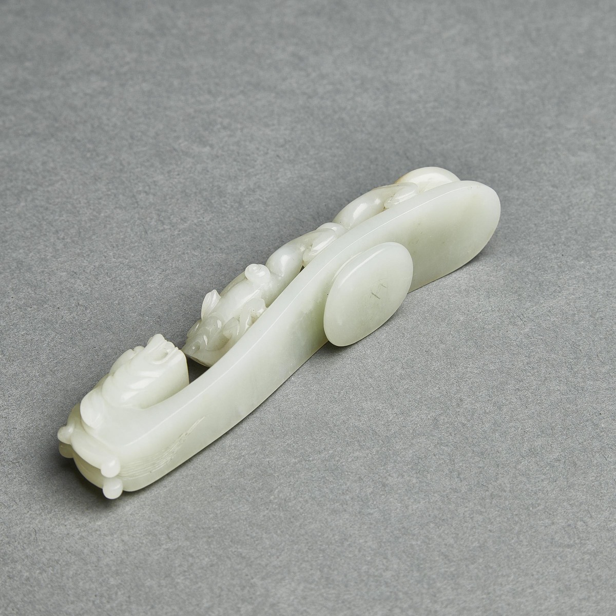 A Pale Celadon Jade 'Dragon' Belt Hook, Qing Dynasty, 清 青白玉雕'苍龙教子'带扣, length 5 in — 12.8 cm - Image 7 of 8