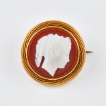 Circular Carved Hardstone Cameo, depicting the profile of a classical maiden, bezel set in an 18k ye