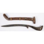 A Malayan knife, bade bade, slender blade 9½", with plain horn hilt, in its wooden sheath. Worn