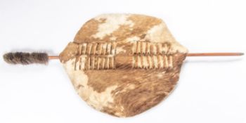 A Swazi cowhide shield, 25½" x 23½", wooden stick 48". VGC £70-100