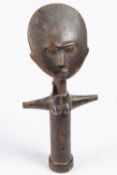 An Ashanti wooden fertility doll, in the form of a standing female figure with flat "moon" face,