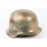 A Third Reich M43 steel helmet, camouflaged finish, SS decal, lining possibly a later replacement.