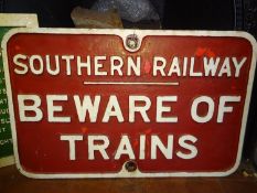 A Southern Railways cast iron 'Beware of Trains' sign. Measures: 56cm x 42cm. White lettering on red
