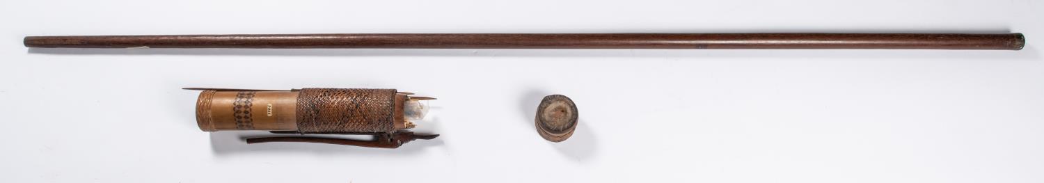 A Borneo head hunters wooden blow pipe, 63" overall, with horn (?) ring around the mouth, together