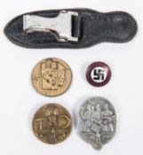A Third Reich sword or dagger hanger from a leather coat; an NSDAP Party badge; 2 alloy day badges
