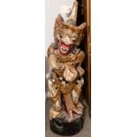 A carved wood Malay kris stand, height 24", depicting a colourfully painted grotesque deity. GC £