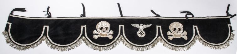 A Third Reich black velvet kettle drum cover, decorated with silver alloy braid skulls and eagle