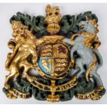 A heavy decorative coat of arms, 14" x 14", cast in resin or plaster composition, coloured with gold