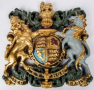 A heavy decorative coat of arms, 14" x 14", cast in resin or plaster composition, coloured with gold