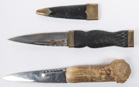 A skean dhu sock knife, blade 3½", brass mounted black wood hilt, in its sheath; also a similar