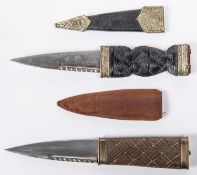 A skean dhu sock knife, blade 3½", glass pommel, in its sheath; another skean dhu with brass mounted