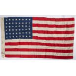 A good quality 48 star US flag, 60" x 34", of stitched construction, edge stamped "USMC 1944" etc.