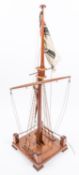 An Imperial German nautical desk ornament in the form of a partly rigged mast flying naval ensign,