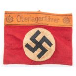 A Third Reich Party armband, red cloth with applied swastika panel and attached "Oberlagerfuhrer"