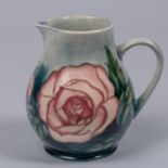 A Moorcroft pottery jug with rose design. Impressed marks etc to base with arrow year cypher, AW and