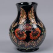 A Moorcroft pottery vase. With orange flowers on dark blue ground. Marks to base, MH, GP, gate