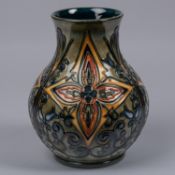 A Moorcroft pottery vase. Abstract foliage designs on a green ground. Marks to base, iron date