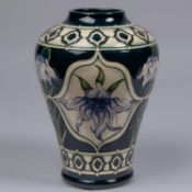 A Moorcroft pottery vase. With lily design on dark blue ground by Marie Penkethman. Impressed