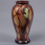 A Moorcroft pottery vase. Leaf shapes in shades of brown on a graded ground. Marks to base, SP, flag