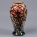 A Moorcroft pottery vase. Stylised poppies on a graded green and peach ground. Marks to base,