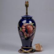 A Moorcroft pottery lamp vase. With anemone design on dark blue ground. Marks to base, MH. H.
