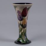 A Moorcroft pottery vase. Tulips on a cream and dark blue ground by Rachel Bishop. Marks to base,