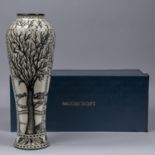 A Moorcroft pottery tall vase. Leafless trees with mushrooms around the bases in black and white