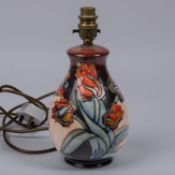 A Moorcroft pottery lamp vase. With multi-colour tulip design. Impressed marks etc to base with