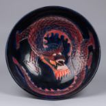 A Moorcroft pottery bowl. Chinese dragon on a dark blue ground. Marks to base. W.260mm. VGC. £80-120