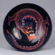 A Moorcroft pottery bowl. Chinese dragon on a dark blue ground. Marks to base. W.260mm. VGC. £80-120