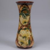 A Moorcroft pottery tall vase. With yellow flowers on brown ground. Impressed marks etc to base,