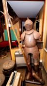 A full size suit of replica armour, probably made for decor or a film prop, complete with a halberd,