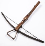 A reproduction of a mediaeval style crossbow, varnished wood stock 27", steel bow and mechanism.