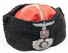 A Third Reich simulated astrakhan "Cossack" cap, with braided red top and 3 part alloy insignia.