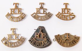 Five T/RE brass shoulder titles: HIGHLAND, W.RIDING, HANTS, LANCASHIRE, and W.LANCASHIRE; also T/