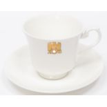 A Third Reich china cup and saucer with gilt eagle and swastika flanked by "AH", made by Allach,