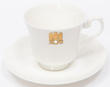 A Third Reich china cup and saucer with gilt eagle and swastika flanked by "AH", made by Allach,