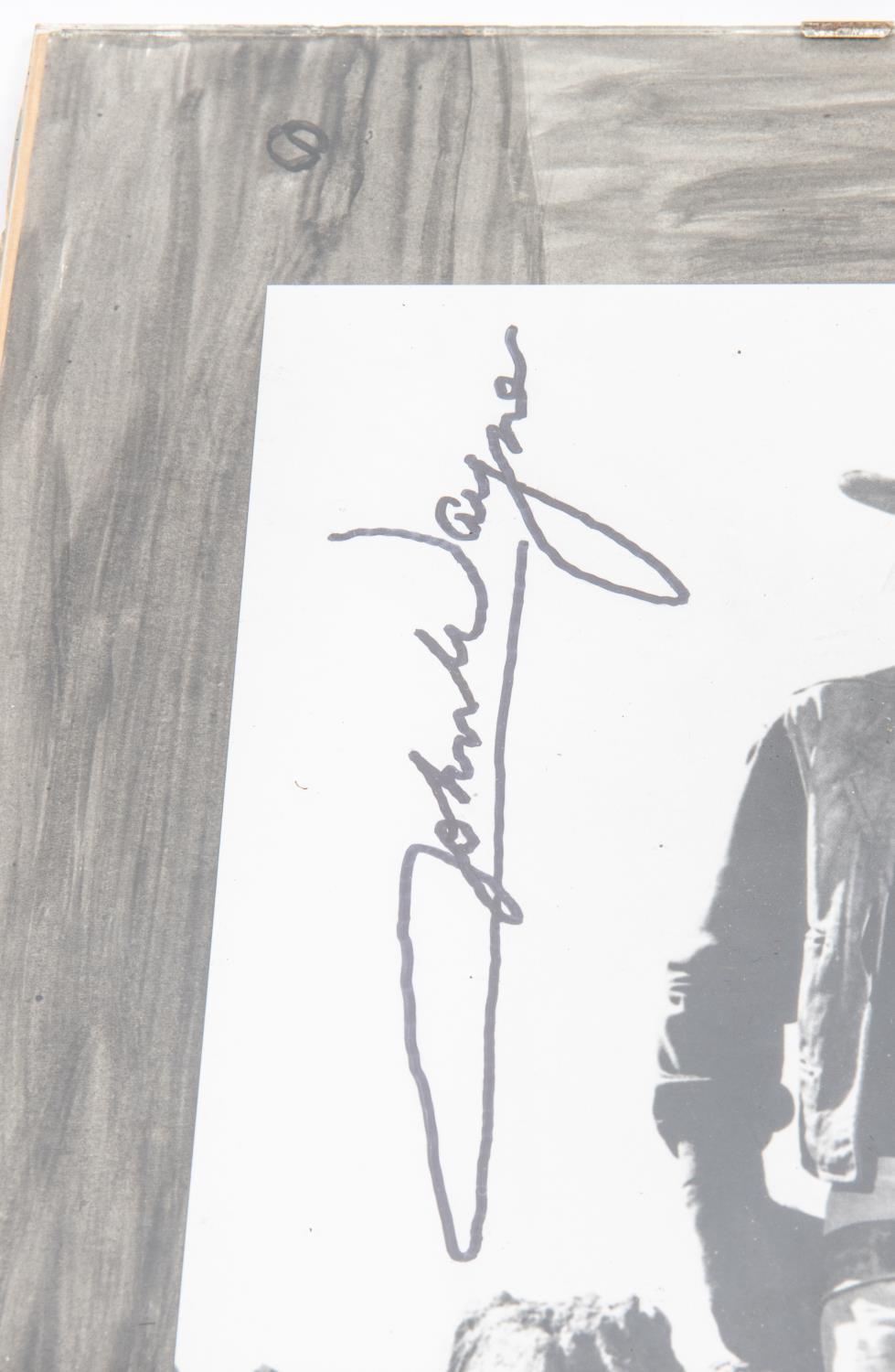 An autographed photograph of John Wayne, 10" x 8", in Western costume, signed vertically. In mount - Image 2 of 3