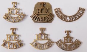 Five T/RE brass shoulder titles: TYNE, HIGHLAND, WESSEX, EAST ANGLIAN, and hand fretted brass