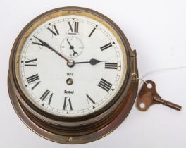 A brass bodied bulkhead/ship's clock, by Sestrel, Roman numerals, with regulator slot above