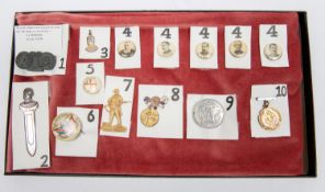 A framed display of Boer War souvenir badges etc, comprising seven celluloid lapel baadges depicting