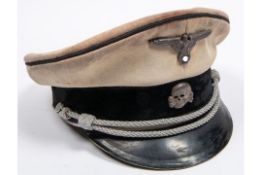 A Third Reich SS officer's tropical peaked cap, white drill body, alloy eagle and skull badges,