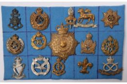 Fourteen cap badges, including 21st County of London, 7th Bn Manchester Regt, pre 1920 Queens, and