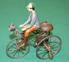 A rare French mid 1800's clockwork tricycle. A simple metal framed bike with metal spoked wheels,